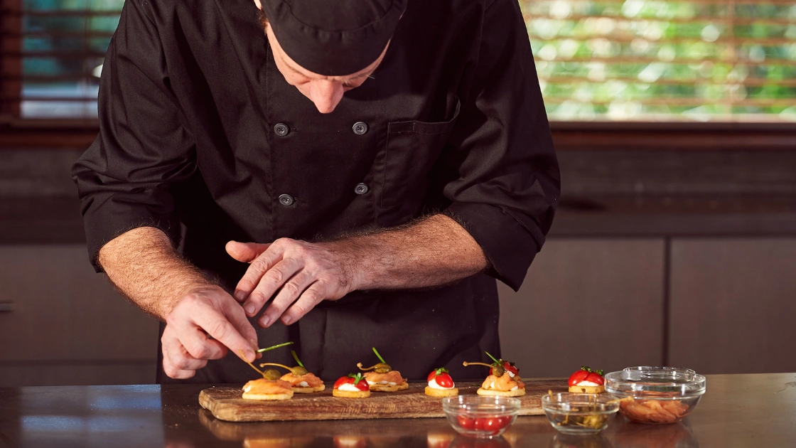 Private chef plating a course in a residential kitchen